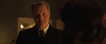 Movie still from “Operation Mincemeat” (2021), directed by John Madden – A man wearing a suit and tie standing in front of a mirror; Close Up shot, Over the shoulder angle