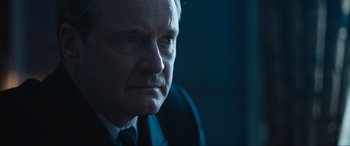Movie still from “Operation Mincemeat” (2021), directed by John Madden – An older man in a suit and tie looking into the distance; Close Up shot, Over the shoulder angle