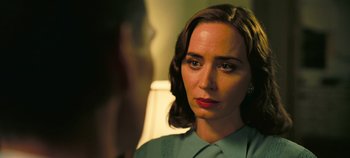 Movie still from “Oppenheimer” (2023), directed by Christopher Nolan – A woman is looking into a mirror while wearing a green shirt; Close Up shot, Over the shoulder angle