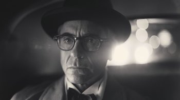 Movie still from “Oppenheimer” (2023), directed by Christopher Nolan – An old man wearing a hat and glasses; Close Up shot, Low angle
