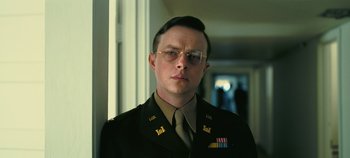 Movie still from “Oppenheimer” (2023), directed by Christopher Nolan – A man in a military uniform wearing glasses; Close Up shot, Low angle