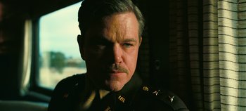 Movie still from “Oppenheimer” (2023), directed by Christopher Nolan – A person wearing a military uniform; Close Up shot, Low angle