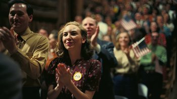 Movie still from “Oppenheimer” (2023), directed by Christopher Nolan – A woman clapping in front of an audience; Medium shot, Low angle