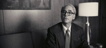 Movie still from “Oppenheimer” (2023), directed by Christopher Nolan – An older man wearing a suit and tie; Close Up shot, Over the shoulder angle