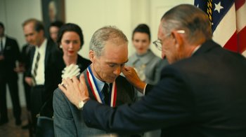 Movie still from “Oppenheimer” (2023), directed by Christopher Nolan – A man putting a medal around a man's neck; Close Up shot, Over the shoulder angle
