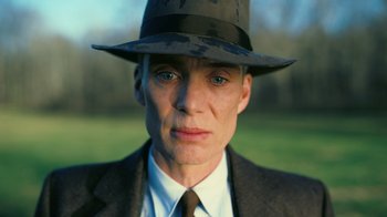 Movie still from “Oppenheimer” (2023), directed by Christopher Nolan – A person wearing a suit and a hat; Close Up shot, Low angle