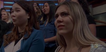 Movie still from “Our Father” (2022), directed by Lucie Jourdan – A group of people standing in a room; Close Up shot, Over the shoulder angle