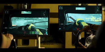 Movie still from “Overhaul” (2023), directed by Tomas Portella – Two computer monitors are shown in a room; Extreme Close Up shot, High angle