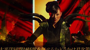 Movie still from “Pacific Rim” (2013), directed by Guillermo del Toro – A woman in a black and yellow jacket with horns in her hair; Medium shot, Low angle