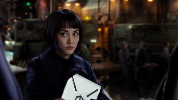 Movie still from “Pacific Rim” (2013), directed by Guillermo del Toro – A woman holding a box while standing in a room; Close Up shot, Over the shoulder angle