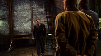Movie still from “Pacific Rim” (2013), directed by Guillermo del Toro – A man standing next to another man with a cane; Medium shot, Over the shoulder angle