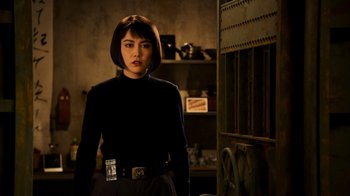 Movie still from “Pacific Rim” (2013), directed by Guillermo del Toro – A woman standing in a dark room wearing a black shirt; Medium shot, Over the shoulder angle