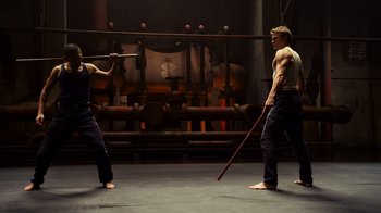 Movie still from “Pacific Rim” (2013), directed by Guillermo del Toro – Two men are practicing martial arts in an industrial setting; Wide shot, Over the shoulder angle