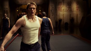 Movie still from “Pacific Rim” (2013), directed by Guillermo del Toro – A man in a white tank top standing next to another man in a white tank top; Medium shot, Low angle