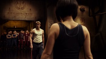 Movie still from “Pacific Rim” (2013), directed by Guillermo del Toro – A group of people standing in front of each other in a room; Medium shot, Over the shoulder angle