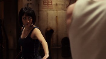 Movie still from “Pacific Rim” (2013), directed by Guillermo del Toro – A woman standing in front of a mirror in front of a wall; Medium shot, Over the shoulder angle