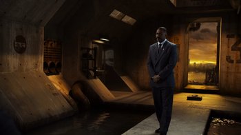 Movie still from “Pacific Rim” (2013), directed by Guillermo del Toro – A man in a suit standing in front of a body of water; Wide shot, Low angle