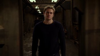 Movie still from “Pacific Rim” (2013), directed by Guillermo del Toro – A man standing in an alley way wearing a black sweater; Medium shot, High angle