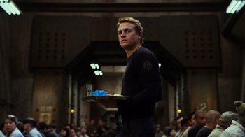 Movie still from “Pacific Rim” (2013), directed by Guillermo del Toro – A man holding a tray of food while standing in front of a group of onlookers; Medium shot, Low angle