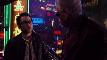 Movie still from “Pacific Rim” (2013), directed by Guillermo del Toro – Two men are talking in front of a neon sign at night; Medium shot, Over the shoulder angle