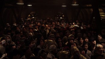 Movie still from “Pacific Rim” (2013), directed by Guillermo del Toro – A large group of people sitting in a dark room; Extreme Wide shot, High angle