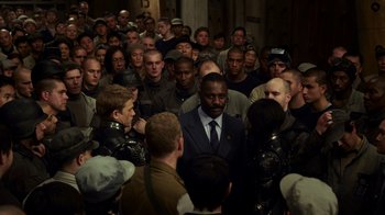 Movie still from “Pacific Rim” (2013), directed by Guillermo del Toro – A group of men standing around a building; Wide shot, High angle