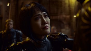 Movie still from “Pacific Rim” (2013), directed by Guillermo del Toro – A woman in a motorcycle suit looking sad; Close Up shot, Over the shoulder angle