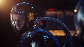 Movie still from “Pacific Rim” (2013), directed by Guillermo del Toro – A man in a black suit with a helmet on his head; Close Up shot, Over the shoulder angle