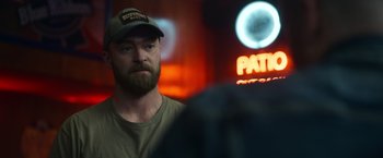 Movie still from “Palmer” (2021), directed by Fisher Stevens – A man with a beard wearing a baseball cap; Close Up shot, Over the shoulder angle