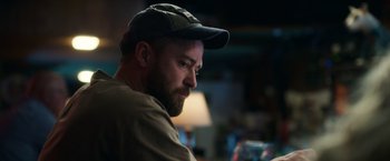 Movie still from “Palmer” (2021), directed by Fisher Stevens – A man with a beard wearing a hat; Close Up shot, Low angle