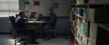 Movie still from “Palmer” (2021), directed by Fisher Stevens – A man sitting at a table in front of a computer; Wide shot, Over the shoulder angle