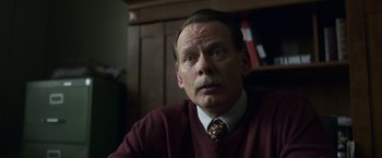 Movie still from “Palmer” (2021), directed by Fisher Stevens – An older man wearing a red sweater and a tie; Close Up shot, Low angle