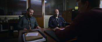 Movie still from “Palmer” (2021), directed by Fisher Stevens – Three men sitting at a table in front of a window; Medium shot, Over the shoulder angle