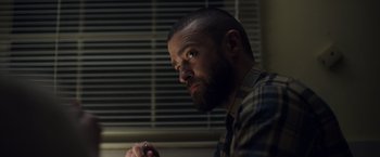 Movie still from “Palmer” (2021), directed by Fisher Stevens – A man with a goatee and a beard is looking to his left; Close Up shot, Low angle