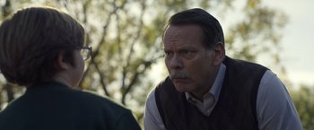Movie still from “Palmer” (2021), directed by Fisher Stevens – An older man with a mustache looking at the camera; Close Up shot, Over the shoulder angle