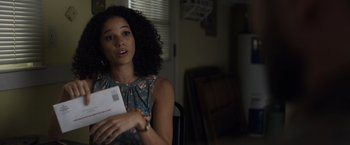 Movie still from “Palmer” (2021), directed by Fisher Stevens – A woman sitting in a chair holding a piece of paper; Close Up shot, Over the shoulder angle