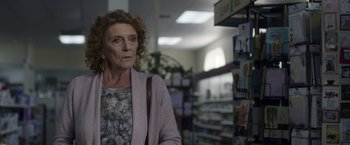 Movie still from “Palmer” (2021), directed by Fisher Stevens – An older woman standing in front of a shelf; Close Up shot, Low angle