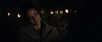 Movie still from “Palmer” (2021), directed by Fisher Stevens – A woman wrapped in a blanket smiling at the camera; Close Up shot, Over the shoulder angle