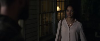 Movie still from “Palmer” (2021), directed by Fisher Stevens – A woman standing in front of a building at night; Medium shot, Over the shoulder angle