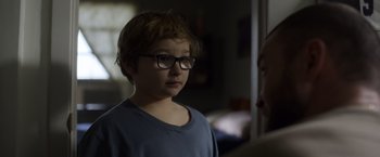 Movie still from “Palmer” (2021), directed by Fisher Stevens – A young boy wearing glasses looking at an older man; Close Up shot, Over the shoulder angle