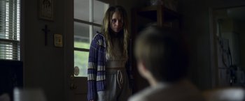 Movie still from “Palmer” (2021), directed by Fisher Stevens – A young woman with a bruised face standing in front of a mirror; Medium shot, Over the shoulder angle