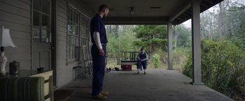 Movie still from “Palmer” (2021), directed by Fisher Stevens – A man and a woman sitting on the porch of a house; Wide shot, Over the shoulder angle