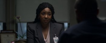 Movie still from “Palmer” (2021), directed by Fisher Stevens – A woman in a suit and a badge on her lapel; Close Up shot, Over the shoulder angle