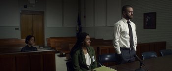 Movie still from “Palmer” (2021), directed by Fisher Stevens – A woman sitting in front of a judge in a courtroom; Medium shot, Low angle