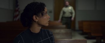 Movie still from “Palmer” (2021), directed by Fisher Stevens – A woman sitting in front of a man in a courtroom; Medium shot, Over the shoulder angle