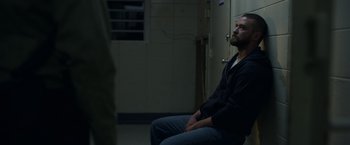 Movie still from “Palmer” (2021), directed by Fisher Stevens – A man sitting on a chair in a dark room; Medium shot, Over the shoulder angle