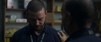 Movie still from “Palmer” (2021), directed by Fisher Stevens – A man with a beard is getting help from another man; Close Up shot, Over the shoulder angle