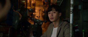 Movie still from “Parasite” (2019), directed by Bong Joon Ho – A young man is sitting in front of a scooter; Close Up shot, Over the shoulder angle