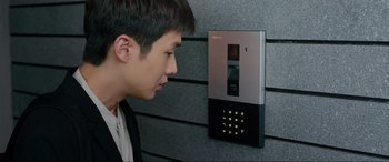 Movie still from “Parasite” (2019), directed by Bong Joon Ho – A young man is looking at a security system; Close Up shot, Over the shoulder angle