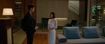 Movie still from “Parasite” (2019), directed by Bong Joon Ho – A man and a woman standing next to each other in a room; Wide shot, Over the shoulder angle